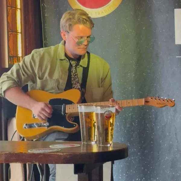 Jannes speelt elektrische gitaar tijdens een optreden in een café